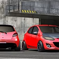 Red Mazda Hatchback Cars at Underground Garage Entrance with Concrete Structure and Yellow Warning Stripes