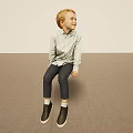 Blonde Young Boy Sitting On Floor In Light Shirt Dark Pants Black Shoes Light Background