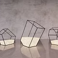 Three Modern Geometric Frame Floor Lamps With White Shade On Reflective Surface And Gray Wall