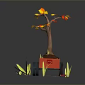 Tree with Yellow and Red Leaves in Red Cart Surrounded by Green Grass
