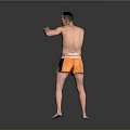 Shirtless Man Practicing Boxing Stance In Orange And Blue Shorts Against Gray Background