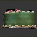 Green Frosted Cake Featuring Pink Decorations Black Berries White Piped Edges and Yellow Bottom Trim