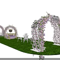 Decorative Event Archway Adorned With Pink Flowers Green Grass And Small Table