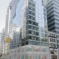Bright Modern Commercial Storefront Window Display Along Downtown Urban Street Beneath Glass Curtain Wall Building