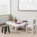 White Children's Table With Unique Shape Black Stools White Chair Colorful Drawing Potted Plant