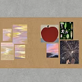 Corkboard Wall Decor with Various Artworks Including Apple Sunset and Fireworks and Side Light Fixtures