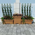 Decorative Garden Planters With Tall Green Plants Pink Flowers Against White Fence Stone Pavement