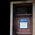 Vintage Old Wooden Door With Blue Sign And Weathered Frame