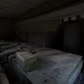 Abandoned Industrial Factory Interior With Concrete Structures Exposed Pipes And Damaged Surfaces