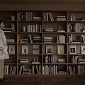 Wooden Bookcase Filled With Books And Decorative Ornaments In Bright Interior With Natural Light