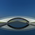 Modern Curved Bridge With Glass Railing Over Waterway And Green Grass