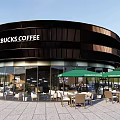 Starbucks Coffee Round Building With Wooden Panels Outdoor Seating Green Umbrellas And Stone Pavement