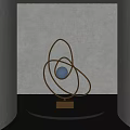 Contemporary Metallic Sculpture With Circular Rings Central Blue Sphere On Black Base And Modern Lighting