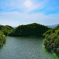 Picturesque Sunny Natural Landscape With Lush Forested Hills And Calm River Under Bright Blue Sky