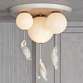 Modern Elegant Chandelier With White Globe Shades Hanging Seal Figures Against Gray Wall