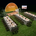 Elegant Outdoor Night Banquet Setup With Long Tables Green Lawn And Yellow Backdrop