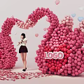 Girl Standing Under Pink Swan Balloon Arch With Heart Decorations And Petals