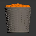Grey Woven Basket Filled With Round Orange Decorative Balls On Dark Surface