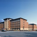 Modern Red Brick School Building With Urban Street View And Surrounding Vehicles