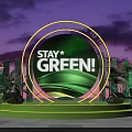 Green Themed Stage With Stay Green Sign And Plant Decorations At Night