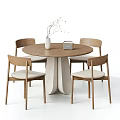 Round Wooden Dining Table with Four Chairs Light Colored Cushions and White Vase Dried Branches