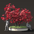 Red Maple Tree With Vibrant Leaves And People Statues In Planter With Green Grass