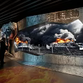Modern Exhibition Hall With Curved Walls Large Screens Showing Fire Scene Trees And Oil Tank