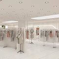 Modern Fashion Retail Counter In Shopping Mall With Mannequins Hanging Clothes And Bright