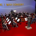 Orchestra Members And Conductor Performing At The 1 Max Concert On Red Carpet Stage