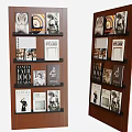 Brown Wooden Bookcase Displaying Books with Black and White and Colorful Covers and Decorative Prints