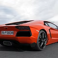 Orange Lamborghini Supercar With Sleek Design Black Wheels On Open Ground Against Cloudy Sky Background