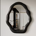 Modern Irregular Shaped Black Frame Mirror Reflecting Indoor Plants And Furniture