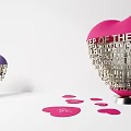 Pink And Purple Heart Shaped Sculptures With Intricate Word Carvings And Scattered Heart Cards