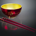 Red Bowl With Yellow Interior And Gold Flower Designs Plus Red Chopsticks With Gold Accents