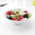 Fresh Mixed Fruits in White Bowl with Strawberries Blackberries Raspberries Kiwi and Green Leaves