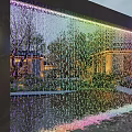 Stunning Water Fountain With Colorful Lighted Water Curtain Reflecting Trees And Buildings In Evening