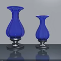 Two Blue Glass Vases With Black Bases On Gray Tabletop Light Gray Background