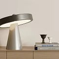 Modern Table Lamp with Conical Base Round Shade on Wooden Cabinet with Books and Decor