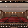 Spacious Conference Hall With Red Seats Stage Red Curtains And Modern Lighting