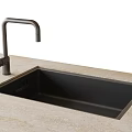 Black Kitchen Sink Installed in Light Colored Stone Countertop with Silver Faucet
