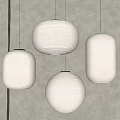 Four White Paper Pendant Lights of Various Shapes Hanging Against Gray Wall