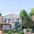 Old Brick Building Covered With Vines Surrounded By Trees And Electric Pole Under Blue Sky