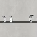 Multiple Modern Faucets In Various Colors And Designs On Light Countertop With Gray Wall