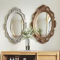 Two Oval Mirrors with Silver Gold Carved Frames Above Wooden Shelf with Vase Green Plants