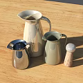Silver Light Green White Milk Jugs Water Pitcher and Wooden Pepper Grinder on Wooden Table