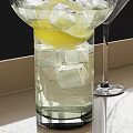 Refreshing Cocktail Drink in Glass with Ice Cubes and Lemon on Black Tray with Martini Glass