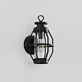 Black Metal Frame Wall Sconce With Transparent Glass Shade And Illuminated Bulb Mounted On Wall