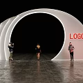 Stylish Event Entrance With White Curved Structure Red LOGO And People Taking