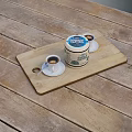 Wooden Cutting Board With Jar And Coffee Cups With Saucers On Wooden Table