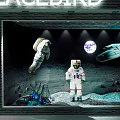 Creative Shop Window Display Featuring Astronauts Earth Spaceship On Moon Surface With Colorful Bottles